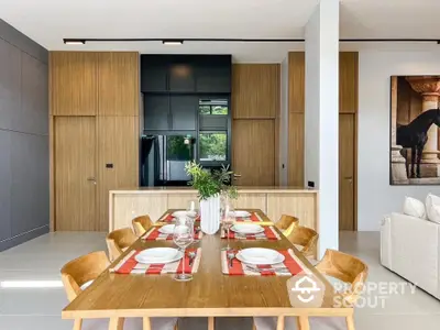 Modern dining area with wooden table and stylish kitchen backdrop