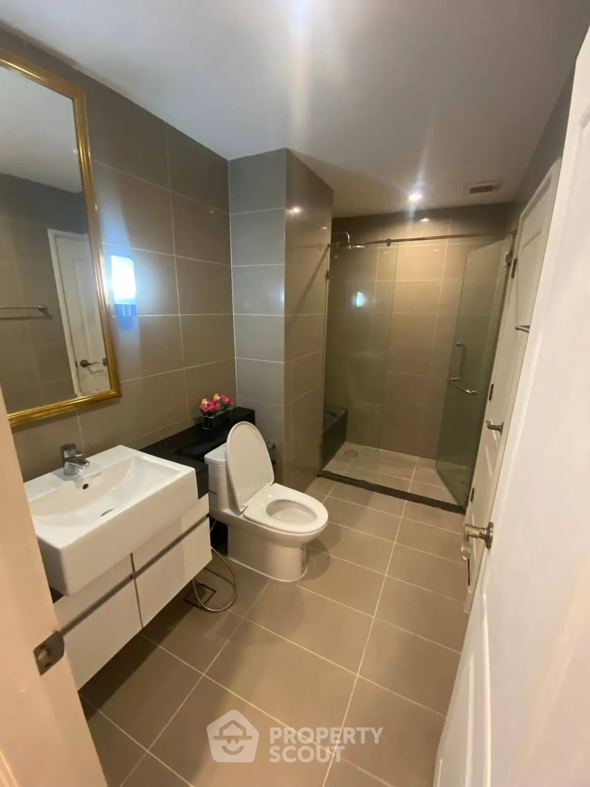 Modern bathroom with sleek design, featuring a glass shower and elegant fixtures.