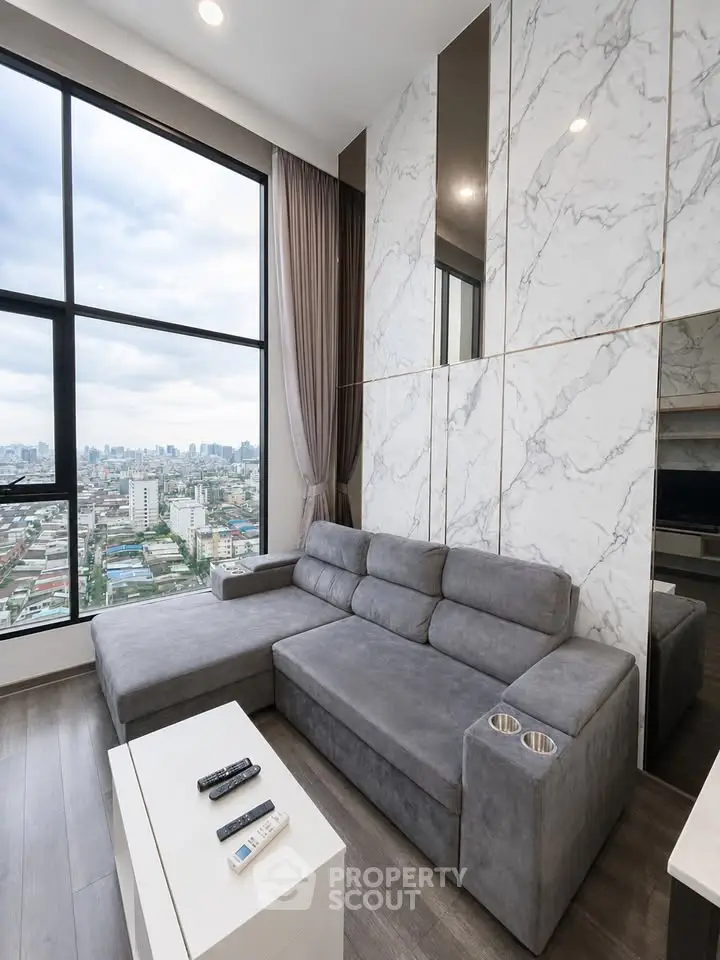 Modern living room with panoramic city view and stylish marble wall design.