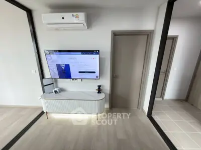 Modern living room with sleek TV setup and air conditioning unit