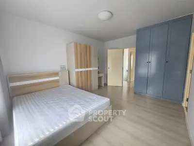 Spacious bedroom with modern furnishings and ample storage in a bright, minimalist design.