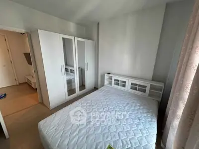 Spacious bedroom with modern white furniture and ample natural light.