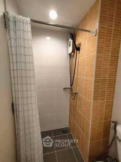 Modern bathroom with shower curtain and tiled walls in a cozy apartment.