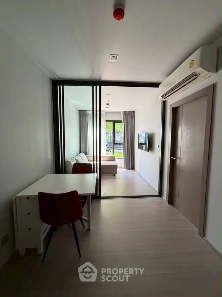 Modern studio apartment with sliding glass doors and natural light