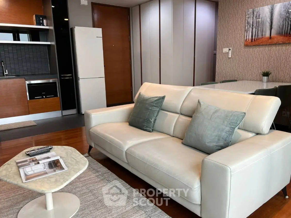 Modern living room with sleek furniture and open kitchen layout in stylish apartment.