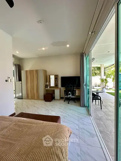 Spacious modern bedroom with garden view and sliding glass doors