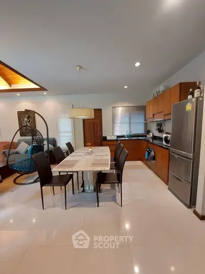 Modern open-plan kitchen and dining area with sleek appliances and stylish decor.