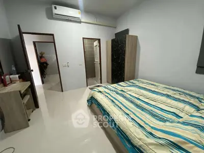 Spacious bedroom with modern decor and air conditioning, featuring a stylish wardrobe and comfortable bedding.