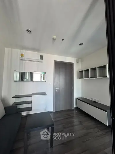Modern living room with sleek furniture and dark wood flooring