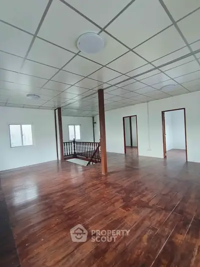 Spacious open-plan interior with wooden flooring and modern ceiling design, ideal for versatile living arrangements.