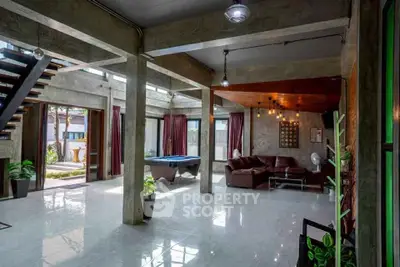 Spacious industrial-style living room with pool table and modern decor