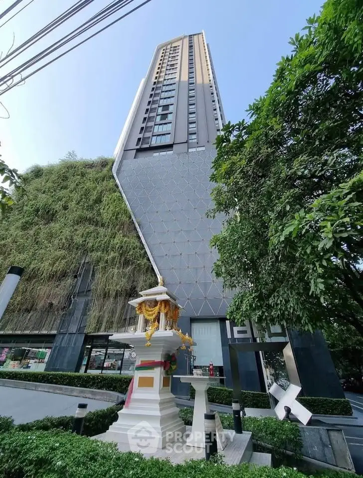 Modern high-rise building with unique architecture and lush greenery facade