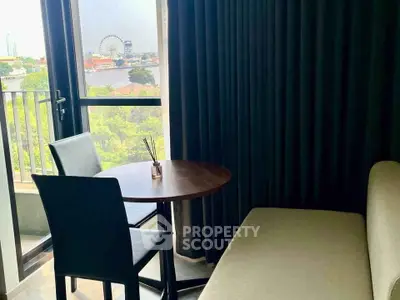 Chic living room with balcony view overlooking cityscape and river, featuring modern furniture and elegant decor.