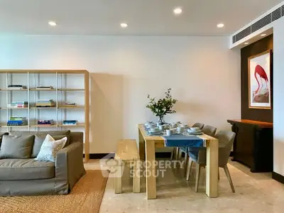 Modern living room with dining area, featuring elegant furniture and stylish decor.