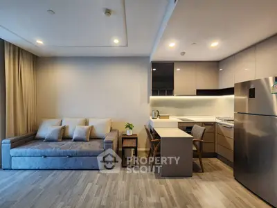 Modern open-layout living room and kitchen with sleek design and cozy seating area.