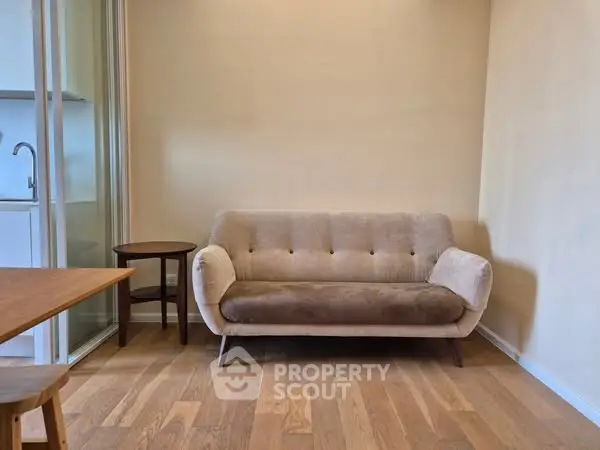 Cozy living room with modern beige sofa and wooden flooring, perfect for relaxation.