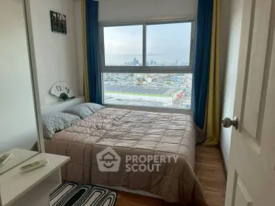 Cozy bedroom with city view, featuring a comfortable bed and modern decor.