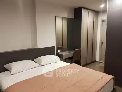 Modern bedroom with cozy bed, sleek wardrobe, and stylish vanity in a contemporary apartment.