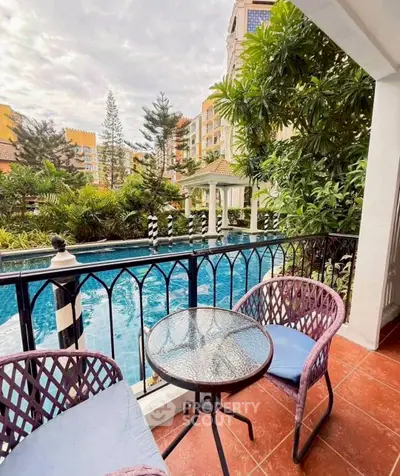 Charming balcony overlooking serene pool and lush greenery in luxury apartment complex.