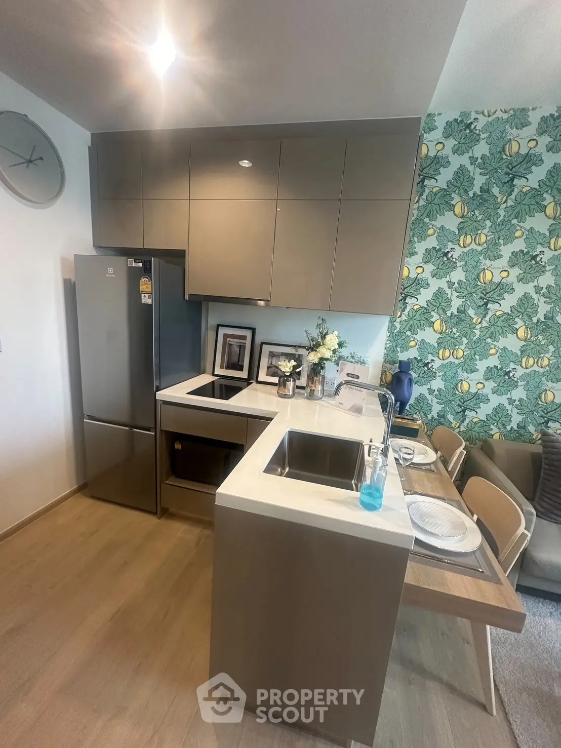 Modern kitchen with sleek cabinetry and dining area, featuring stylish decor and ample natural light.