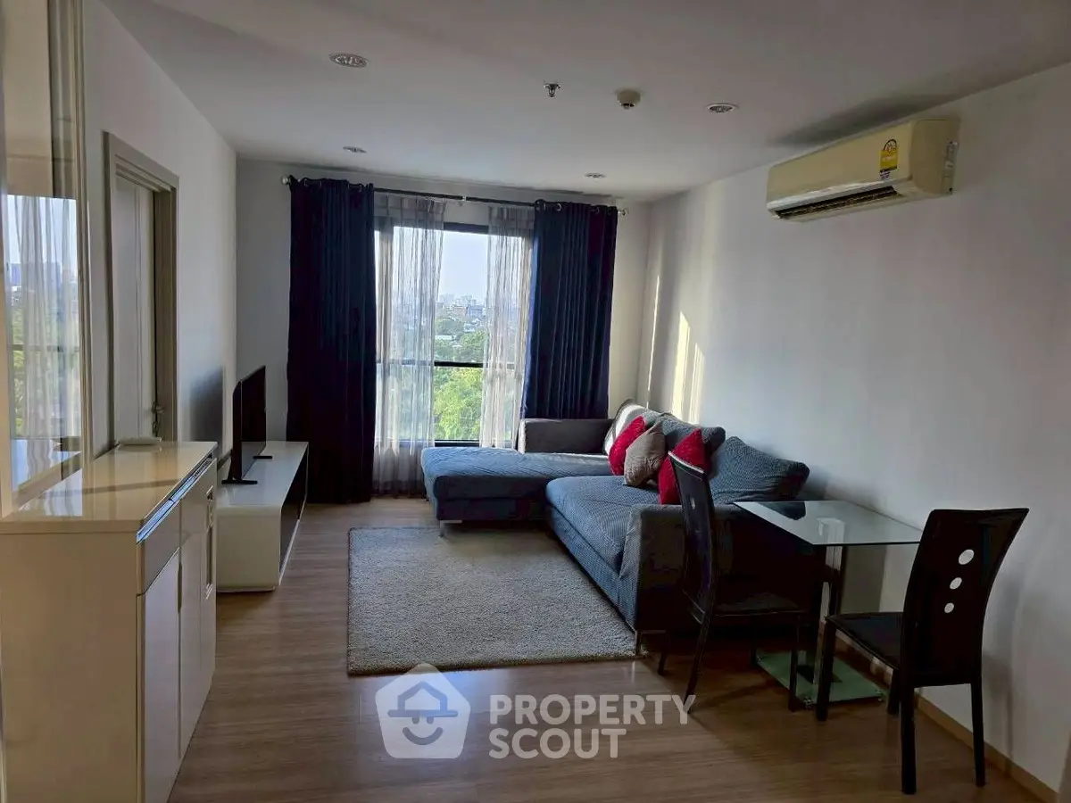 Modern living room with large window and stylish furniture in a cozy apartment.