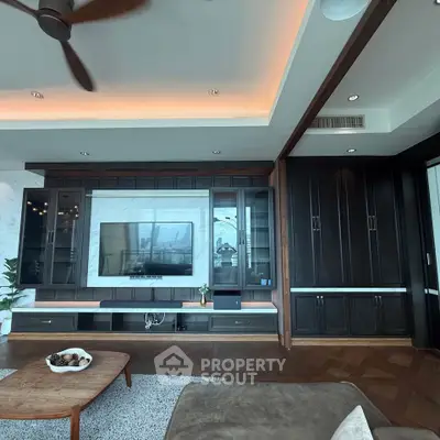 Luxurious living room with modern entertainment center and elegant wood finishes.