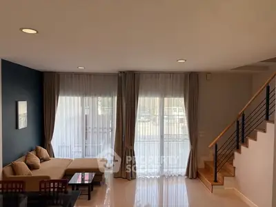 Spacious living room with modern decor and large windows for natural light.