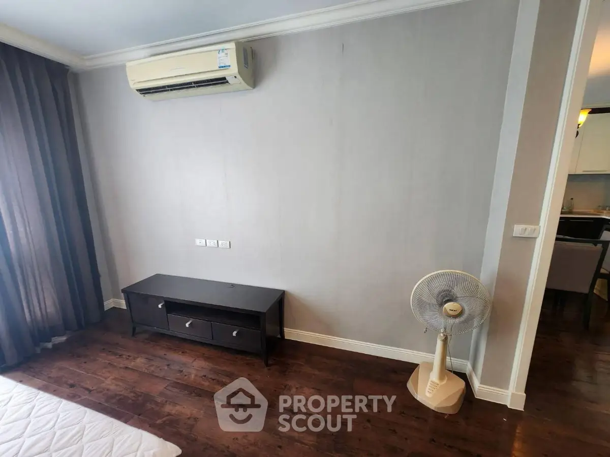Modern bedroom with air conditioning and wooden flooring in a stylish apartment.
