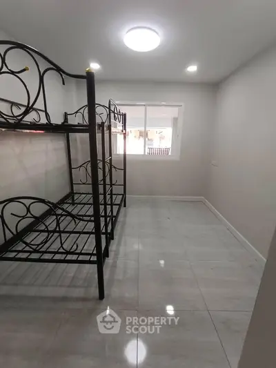 Spacious bedroom with metal bunk beds and large window for natural light.