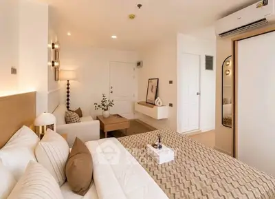Luxurious bedroom with modern decor and cozy seating area in a stylish apartment.