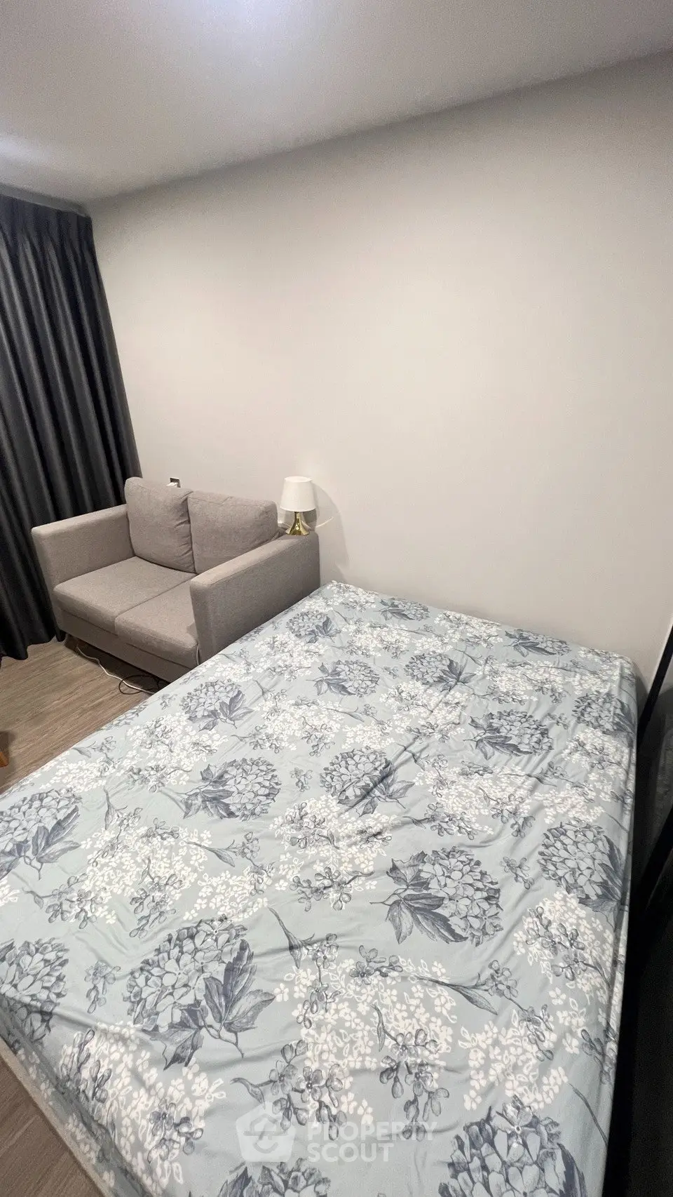 Cozy bedroom with floral bedding and a comfortable sofa, perfect for relaxation.