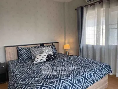 Cozy bedroom with stylish decor and ample natural light from large window.