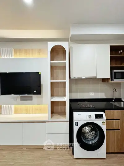 Modern apartment interior with built-in TV unit and washing machine in stylish kitchen.