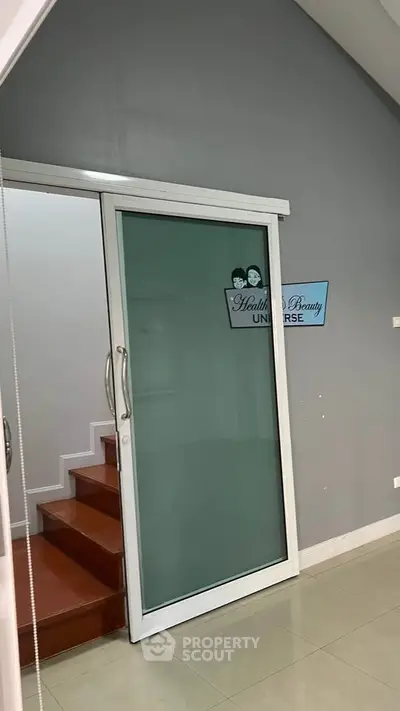 Modern interior with sliding glass door and staircase, ideal for health and beauty business.