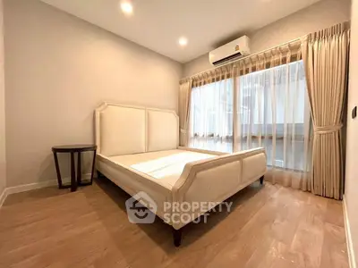 Spacious bedroom with elegant bed frame and large window for natural light.