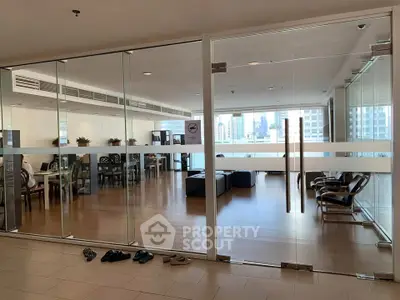 Spacious modern living room with glass doors and city view, perfect for urban living.