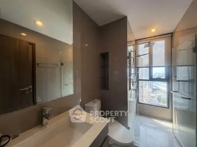 Modern bathroom with city view, featuring sleek fixtures and large window for natural light.