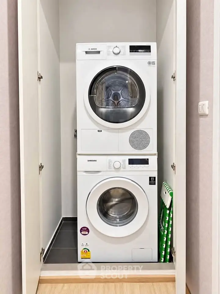 Compact laundry area with stacked washer and dryer in modern apartment.