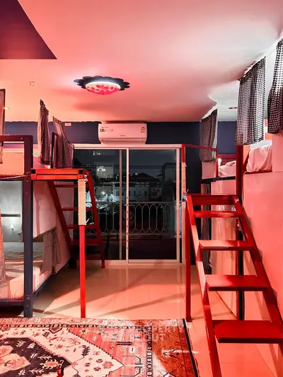 Modern shared bedroom with bunk beds and balcony access, featuring stylish lighting and cozy curtains.