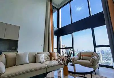 Luxurious high-rise living room with panoramic city views and elegant furnishings.