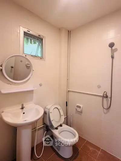 Compact bathroom with shower, sink, and toilet in a minimalist design.