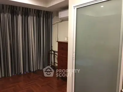 Cozy bedroom with wooden flooring and sliding glass door