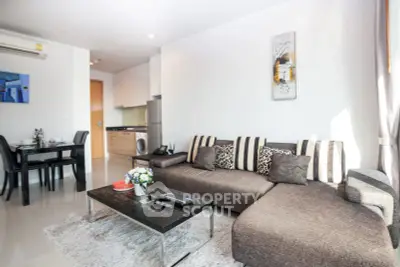 Modern living room with stylish sofa and open kitchen layout in bright apartment