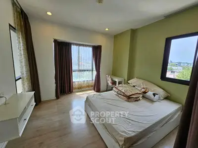 Bright and airy bedroom with large windows and modern decor in a stylish apartment.