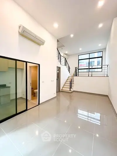 Spacious modern living room with high ceilings and sleek design in a contemporary home.