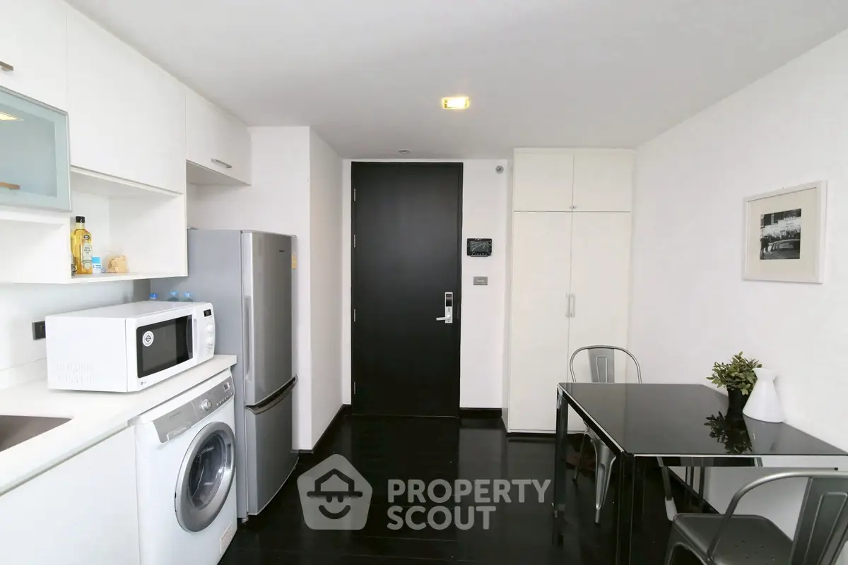 Modern kitchen with sleek appliances and dining area in a stylish apartment.