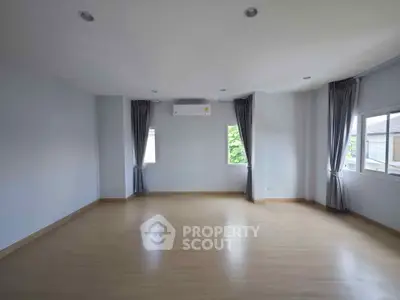 Spacious empty room with large windows and air conditioning, perfect for customization.