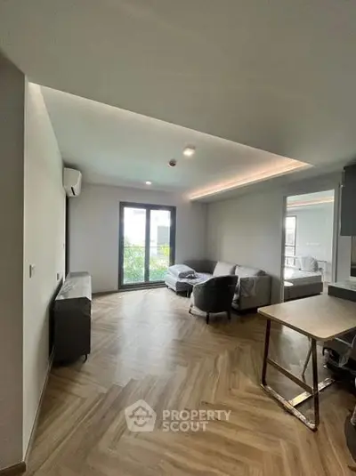 Modern living room with stylish furniture and large window offering natural light.