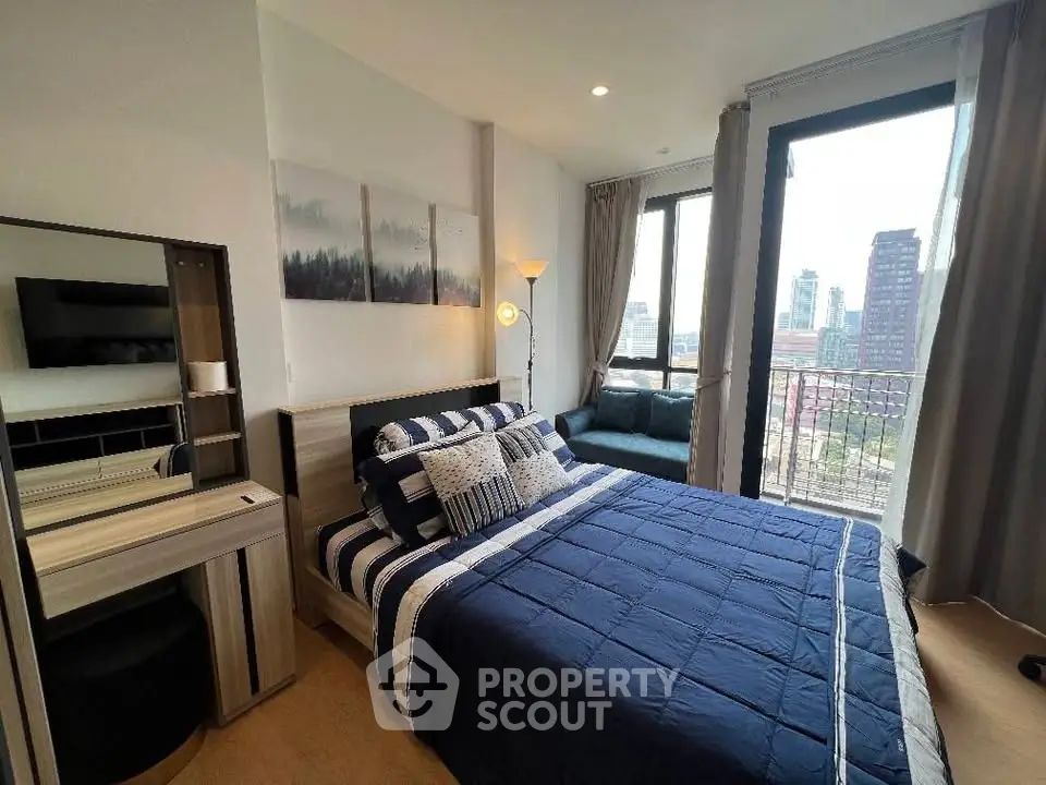 Modern bedroom with city view, stylish decor, and cozy seating area.