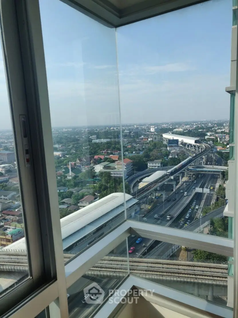 Stunning high-rise view from a modern balcony overlooking cityscape and highways.